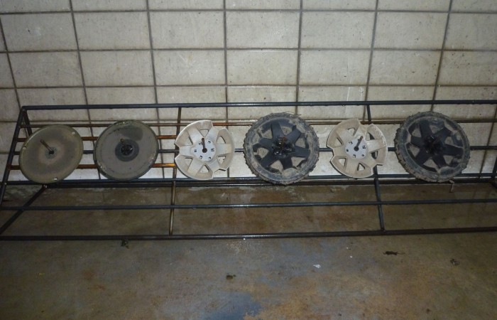 Die Hinterräder mit Radabdeckungen, der Messerteller und Gleitteller werden auf eine Reinigungsvorrichtung montiert.